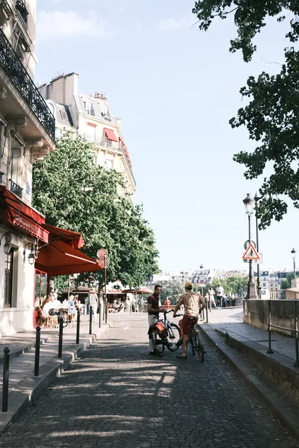 A Paris street with café awnings and cyclists