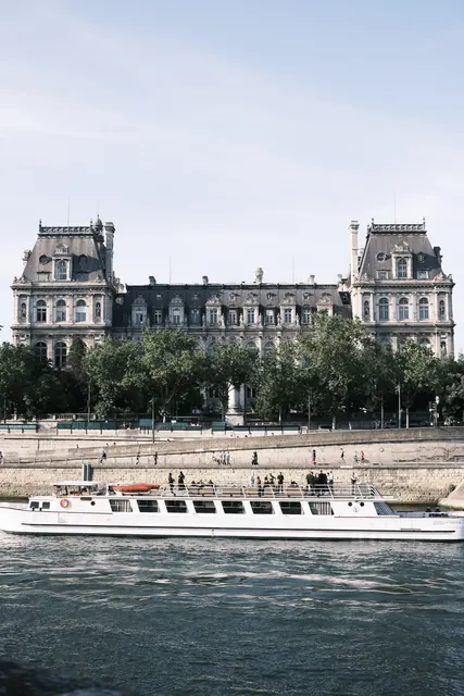 A riverboat passing an ornate building along the Seine