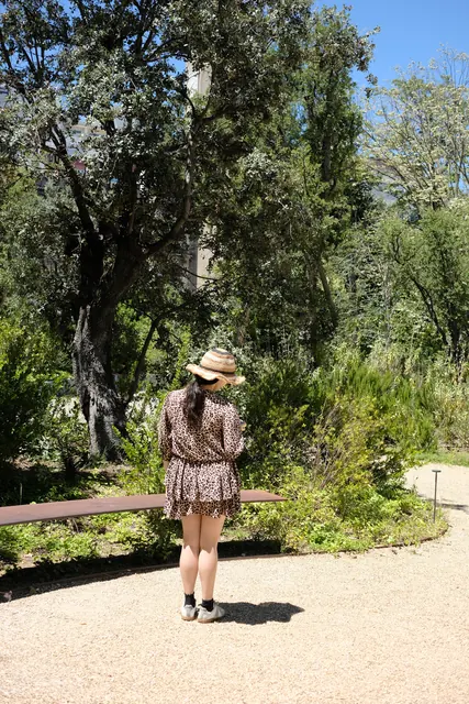A woman in a straw hat standing in a garden