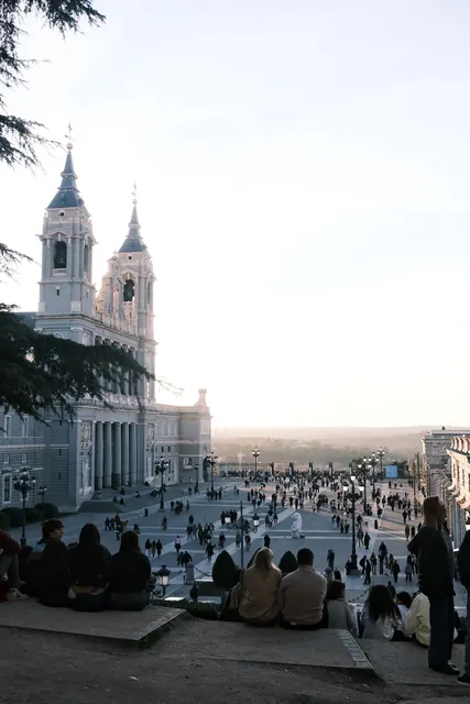 A crowd on the steps below a cathedral at sunset